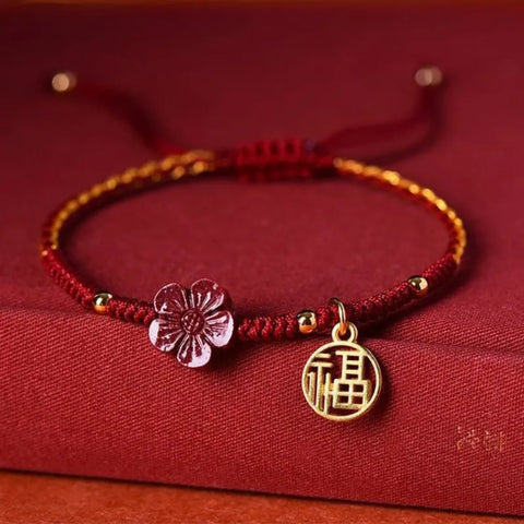 Rotes Schnurarmband mit kleinem roten Blumenanhänger - Viel Glück und Energie