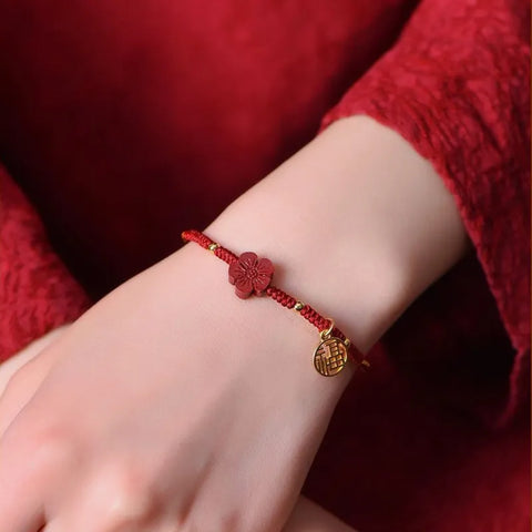 Rotes Schnurarmband mit kleinem roten Blumenanhänger - Viel Glück und Energie